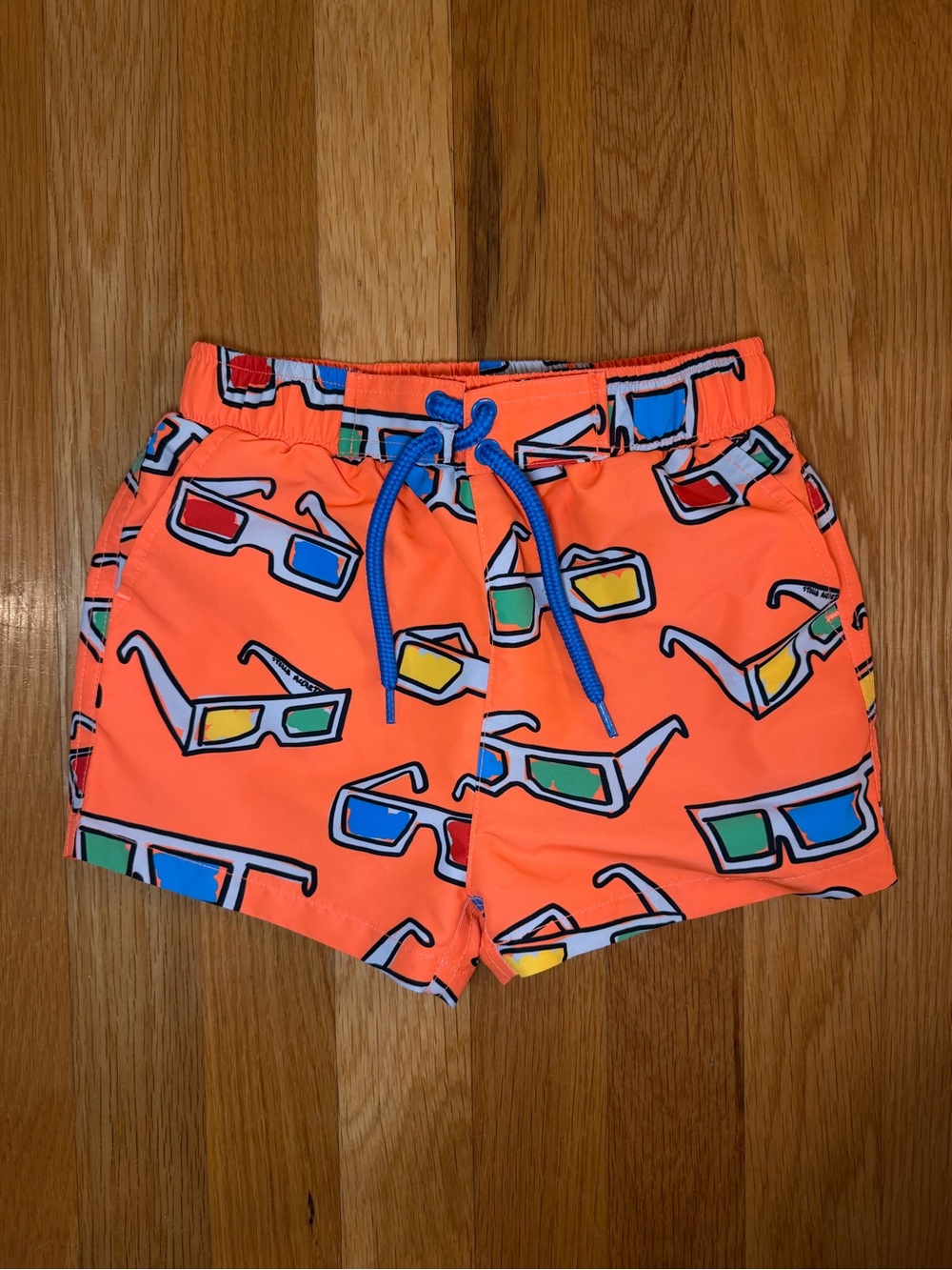 Stella McCartney Kids Neon Coral Swim Trunks with Sunglass Print